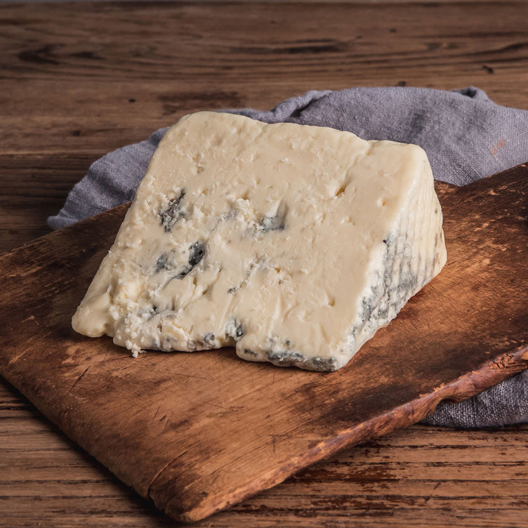 Organic wedge of Crater Lake Blue on wooden cutting board