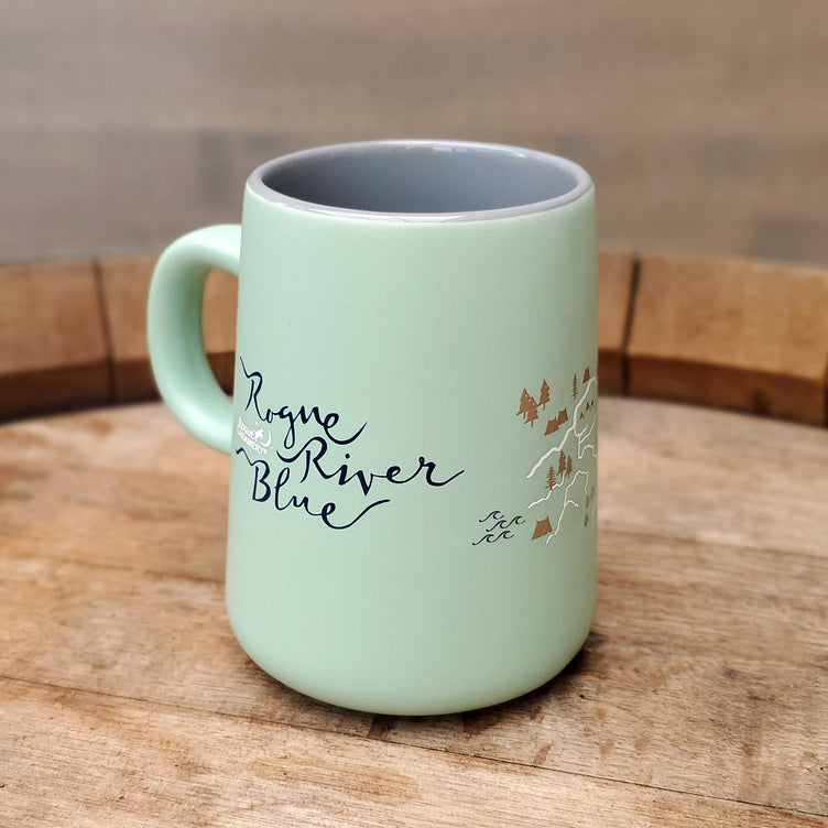 Mint colored mug on wooden cutting board