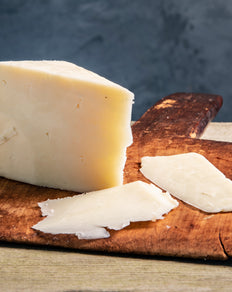 Organic Touvelle Cheese on cutting board with cheese slices