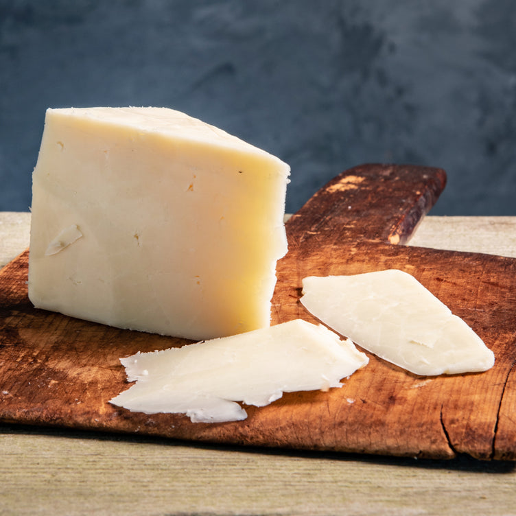 Organic Touvelle Cheese on cutting board with cheese slices