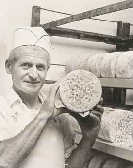Man holding organic blue cheese wheel