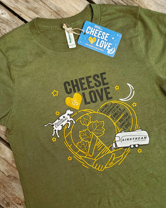 Cheese is love shirt with a cow jumping over a heart on wooden background