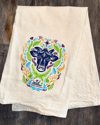 Floral cow print on tea towel on wooden background