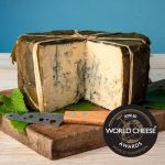 Rogue River Blue Whole Wheel cut to expose deep blue veins in the cheese with Leaves and Cheese Knife