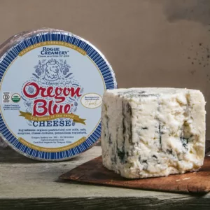 Rogue Creamery Organic Artisan Organic Oregon Blue Cheese Quarter Wedge with Whole Wheel in Background