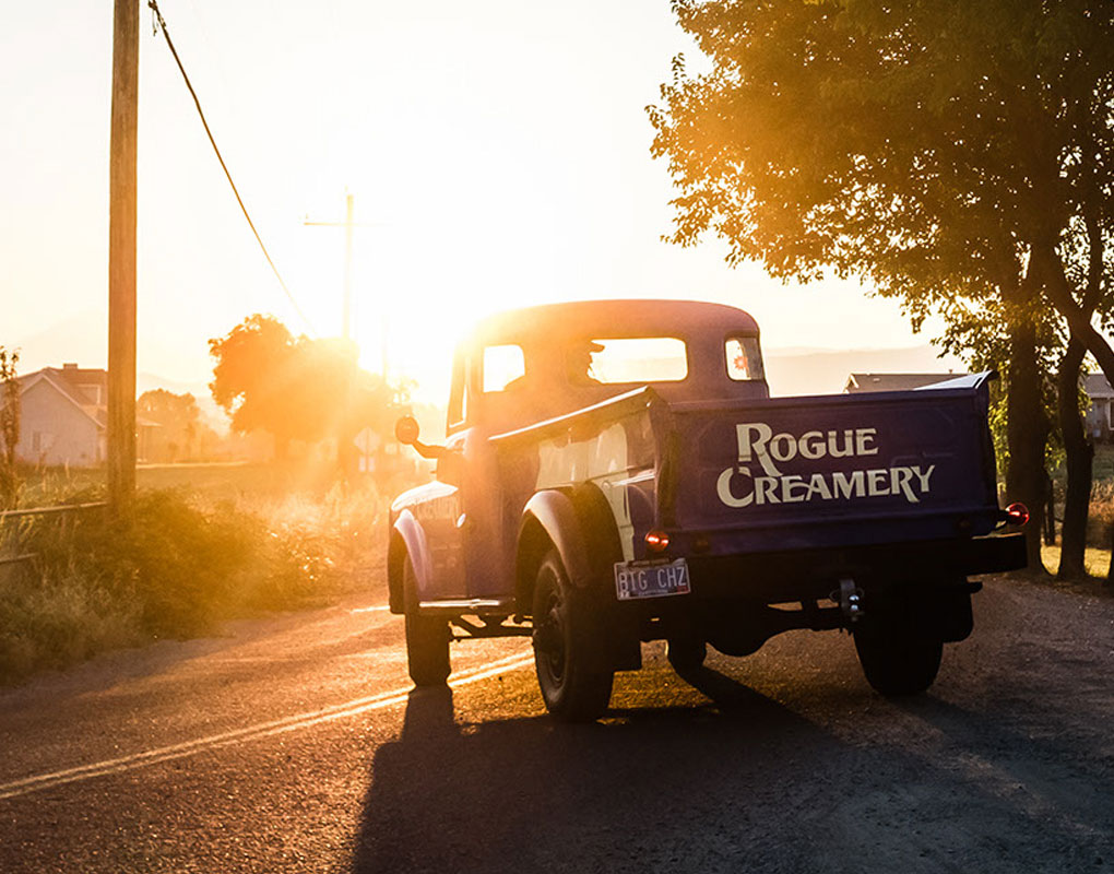 Rogue Creamery Truck driving down country road during sunset
