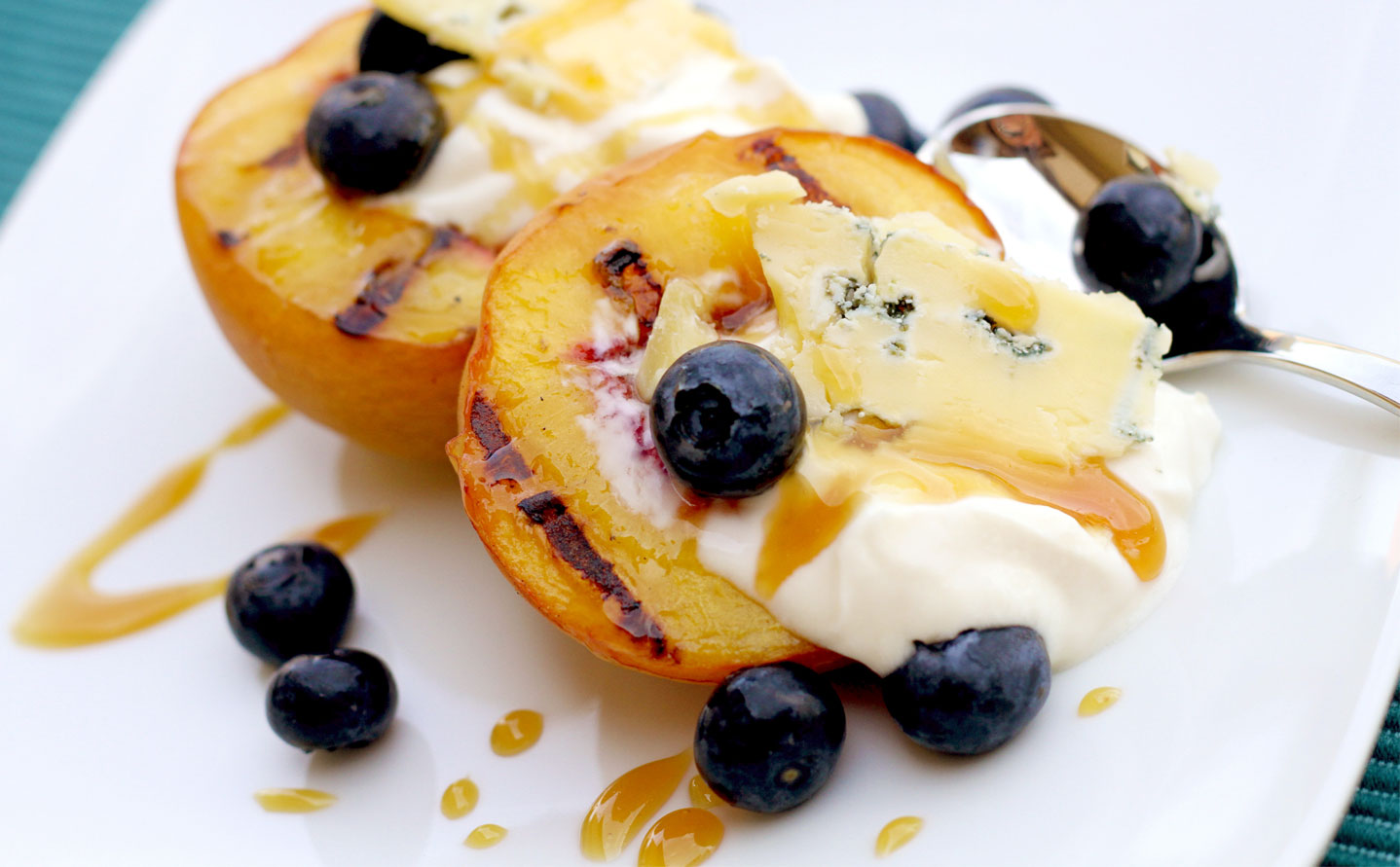 Caveman Blue Cheese on grilled peaches with blueberries and honey