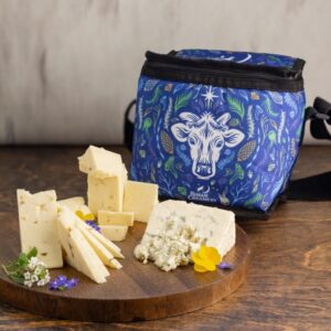 Cheddar and Blue Cheese on wooden cutting board with a flora cow cooler bag