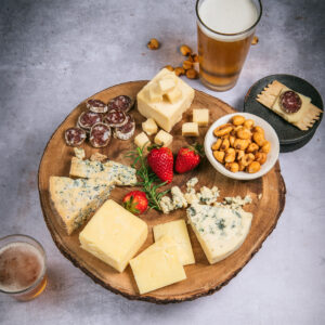 Three Cheers for Cheese gift set on cheese board with a glass of bear and crackers