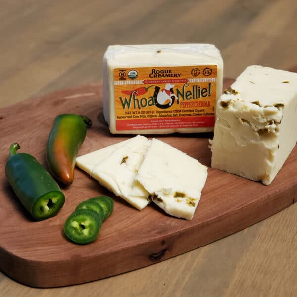 Rogue Creamery Whoa Nelle pepper cheddar on wood block with jalapeno slices.