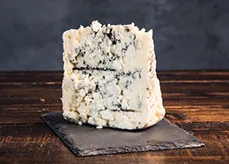 Blue Cheese wedge on cutting board with honey