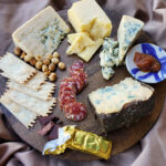 Rogue Creamery Best of the Pacific Northwest Gift Set containing hazelnuts, blue cheese, cheddar cheese, crackers, salami, and jam