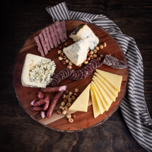 Rogue Creamery organic cheeses and Olympia Provisions meat products on cutting board with banner